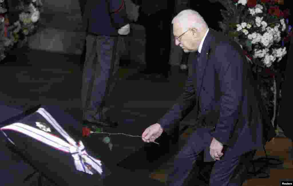 Current Czech President and Havel's longstanding political rival Vaclav Klaus places a flower in front of the late leader's coffin inside Prague Castle.