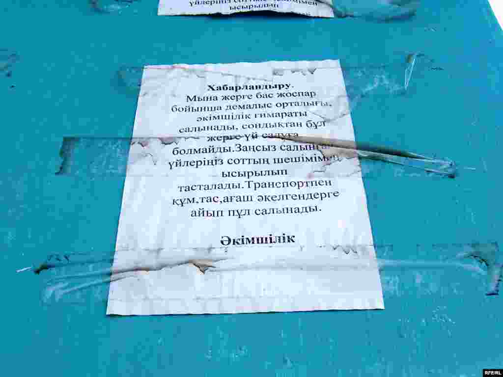 Объявление гласит, что здесь будут построены развлекательный центр и здание администрации. "Самострой будет снесен". - Объявление гласит, что здесь будут построены развлекательный центр и здание администрации. Запрещается строить что-либо иное, дома будут снесены, а доставка стройматериалов будет наказываться штрафом.