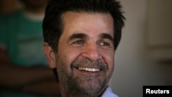 Iranian film director Jafar Panahi smiles, following his release on bail, at his home in Tehran in 2010.