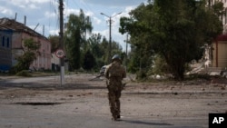 A Ukrainian soldier walks through the center of the town of Sudzha in Russia's Kursk region.