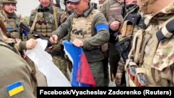 უკრაინის ხარკოვის რეგიონი, სოფელი კაზაჩია ლოპანი. სოფლის განთავისუფლების შემდეგ უკრაინელი სამხედროები ხევენ რუსეთის დროშას. 2022 წლის 12 სექტემბერი