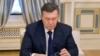 Viktor Yanukovych looks down at his glasses before signing an agreement in Kiev on February 21 to end the country's worst crisis since independence.