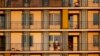 O persoană urmărește apusul din balconul apartamentului său din București