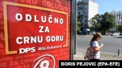 Žena prolazi pored predizbornog bilborda Demokratske partije socijalista (DPS) uoči parlamentarnih izbora u Podgorici, Crna Gora, 27. avgusta 2020.