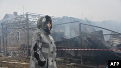 O localnică din Harkov trece prin fața casei vecinilor ei, distrusă de un atac cu drone la Harkov, pe 25 decembrie.
