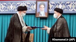 Iranian Supreme Leader Ayatollah Ali Khamenei (left) gives his official seal of approval to newly elected President Ebrahim Raisi in an endorsement ceremony in Tehran on August 3.