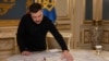 Președintele Ucrainei, Volodimir Zelenski, le arată jurnaliștilor agenției Reuters o hartă cu depozitele de minereuri rare pe care vrea să le împartă cu Statele Unite. 