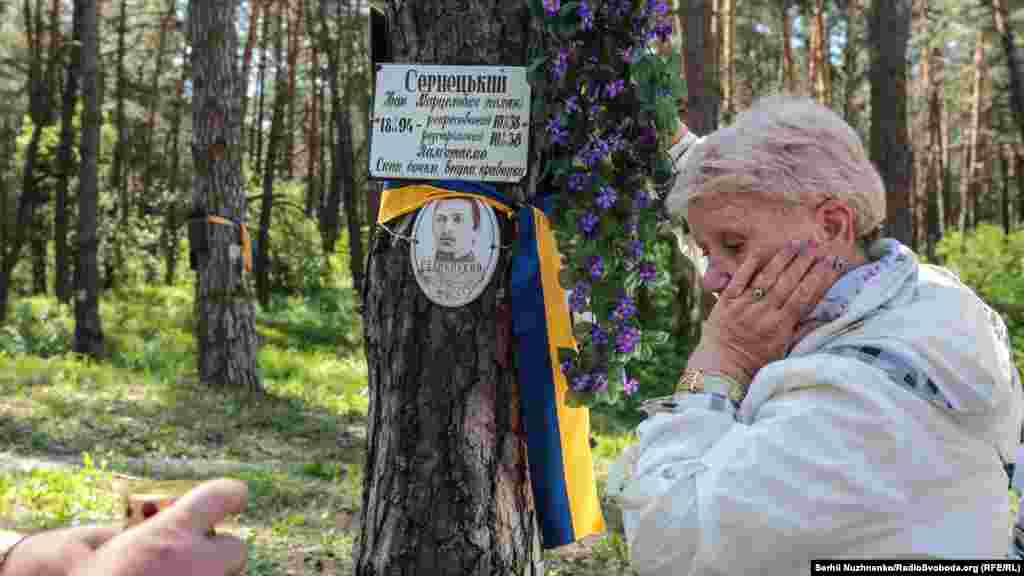Онука Ольга Піддубна-Сарнецька біля таблички з прізвищем її діда.Лише в 2014 році сімя дізналась де місце розстрілу і поховання 