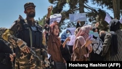 Talibanski borac čuva stražu dok afganistanske žene uzvikuju slogane tokom protestnog skupa u blizini pakistanske ambasade u Kabulu 7. Septembra 2021.