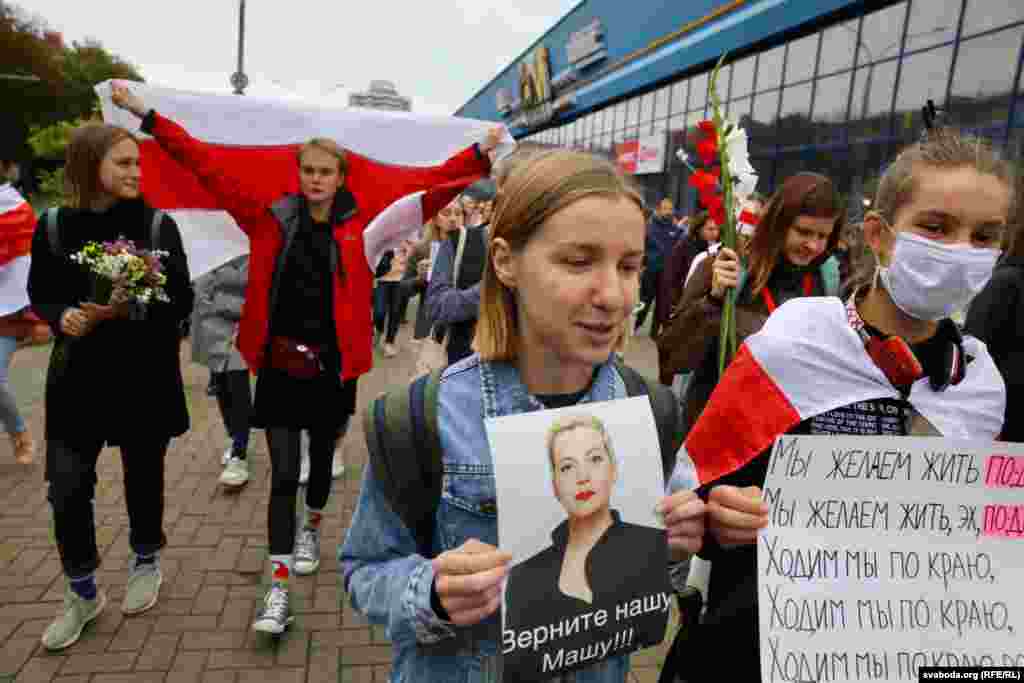 Учасниця протесту тримає фотографію Марії Колесникової з написом: «Поверніть нашу Машу!!!» на марші до проспекту Незалежності в центрі Мінська. А жінка біля неї тримає табличку, на якій написано: «Ми хочемо жити по-іншому»
