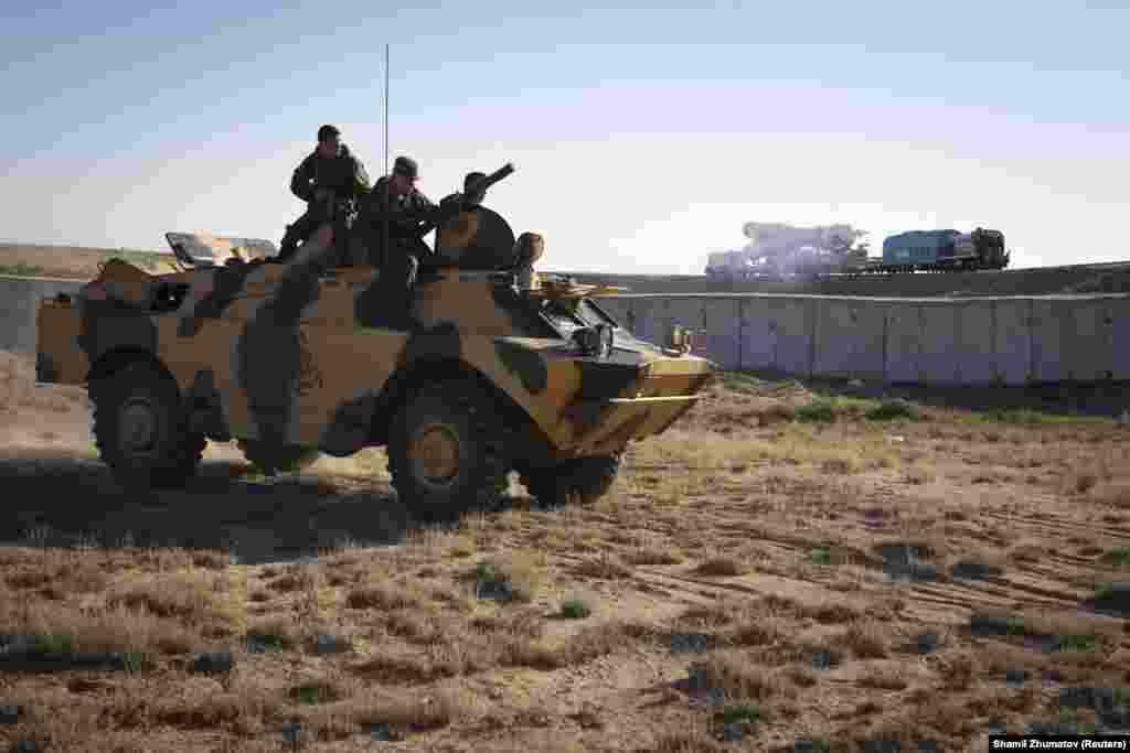 Russian military personnel watch from an armored vehicle as a Soyuz is transported to the launchpad. Baikonur is seen as a potential target for terrorist attacks. 