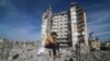 Palestinski dečak sedi ispred stambene zgrade uništene u izraelskom napadu na Rafu, Pojas Gaze, 9. mart 2024.