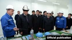 Президент Ошто заводдун макети менен таанышууда.
