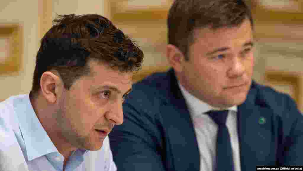 Володимир Зеленський та Андрій Богдан в Офісі президента. Призначення Андрія Богдана порушувало аж два положення закону України «Про очищення влади». Про це заявила голова Громадської ради з питань люстрації при Мін'юсті Тетяна Козаченко. Натомість у команді ж президента Володимира Зеленського наполягали, що призначення Андрія Богдана головою Адміністрації президента України не підпадало під закон, оскільки голова адміністрації не є державним посадовцем і не виконує жодних владних повноважень