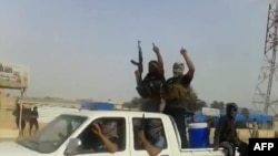A screen grab taken from a video uploaded to YouTube on June 17 allegedly shows militants ISIL parading with their weapons in the northern Iraqi city of Baiji. 