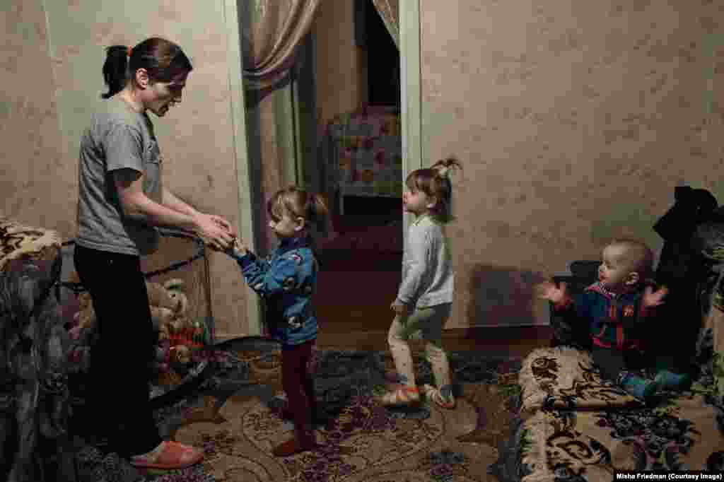 33-річна Тетяна зі своїми трьома дітьми. Вона заразилася ВІЛ від свого чоловіка, який був наркозалежним і помер від ускладнень СНІДу в січні 2016 року. Родина покинула свою домівку під час важких боїв і тепер живе в Краматорську на Донеччині, де їх підтримують неурядові організації та релігійні групи. Вона не може працювати, оскільки єдина, хто доглядає дітей 