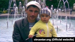 A file photo of Reshat Ametov with one of his children. The Crimean Tatar activist's killing in 2014 is still unsolved. 