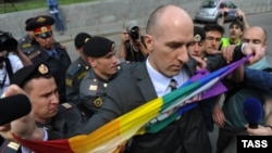 Russian police detain a gay-rights activist after several people gathered for a parade in Moscow in May.