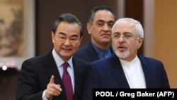 Iran's Foreign Minister Mohammad Javad Zarif (right) arrives with his Chinese counterpart, Wang Yi, for a joint press conference in Beijing on December 5, 2016.