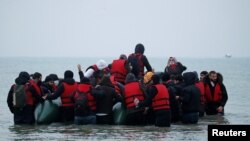 Migranti se ukrcavaju na gumeni čamac napuštajući obalu na sjeveru Francuske, 24. novembar 2021. 