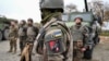 Soldați ucraineni din Brigada Mecanizată Separată 155 lângă vehicule militare, în timpul unui exercițiu de antrenament în Franța. 
