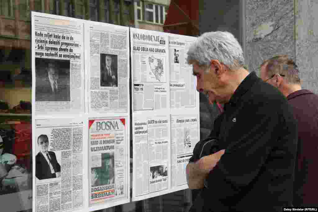 Sarajevans stop to look at pages from war-era newspapers posted in shop fronts along the city’s main Titova Street as part of the commemorations.