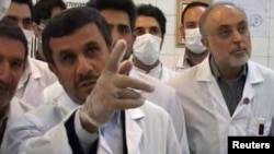 Iranian President Mahmud Ahmadinejad watches as nuclear fuel rods are loaded into a research reactor in Tehran in this still from a February 15 video