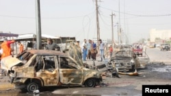 Residents gather at the site of a bomb attack in Basra on May 20.
