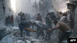 Syria - Syrian Civil Defence workers and pedestrians clear debris after an alleged air strike by Syrian government forces in the Bab al-Nairab neighboured the northern Syrian city of Aleppo on November 12, 2014