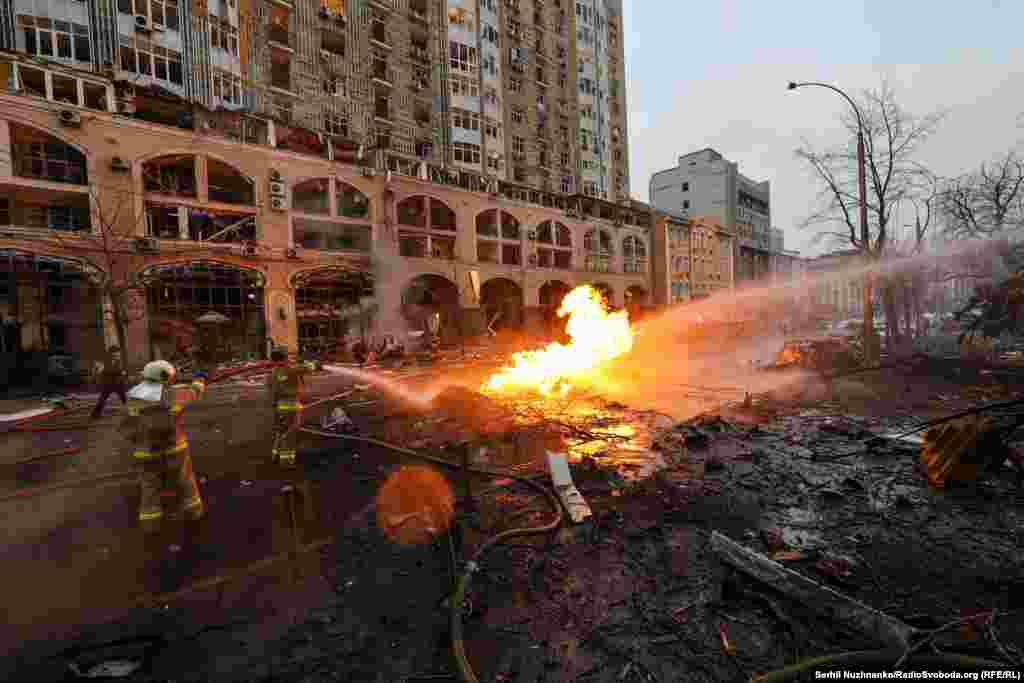 Pompierii înceacă să stingă incendiile, prin resturile unor clădiri. Autoritățile militare ucrainene au afirmat că Rusia a tras opt rachete către Kiev.