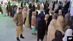 Women in Quetta wait their turn to cast their ballots at a polling station in the country' parliamentary elections on February 8.