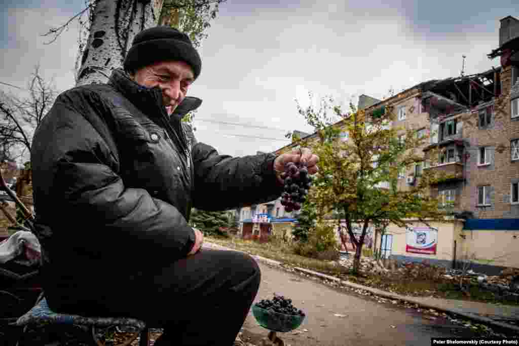 Житель Горлівки – Микола – продає виноград, який він вирощує у своєму саду. Населення повертається в свої будинки, але знайти роботу дуже складно, Горлівка, Донецька область, жовтень 2014 року