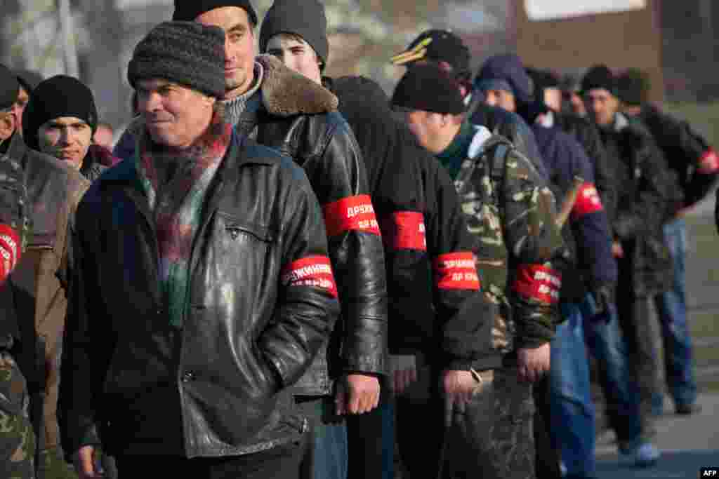 Учасники так званої кримської самооборони шикуються на площі перед пам'ятником Леніну в Сімферополі, 14 березня 2014 року
