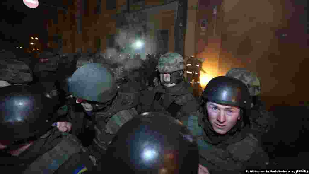 Протестующие бросают камни и пиротехнические средства через головы милиции 