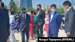 Первый заместитель председателя партии «Нур Отан» Бауыржан Байбек (второй справа) на церемонии открытия детской площадки. Нур-Султан, 27 мая 2021 года.