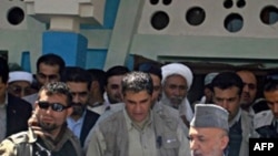 Afghan President Hamid Karzai (right) visits the village of Azizabad in early September.