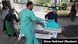 A wounded woman arrives for treatment at a hospital after a blast in Kabul on July 25.