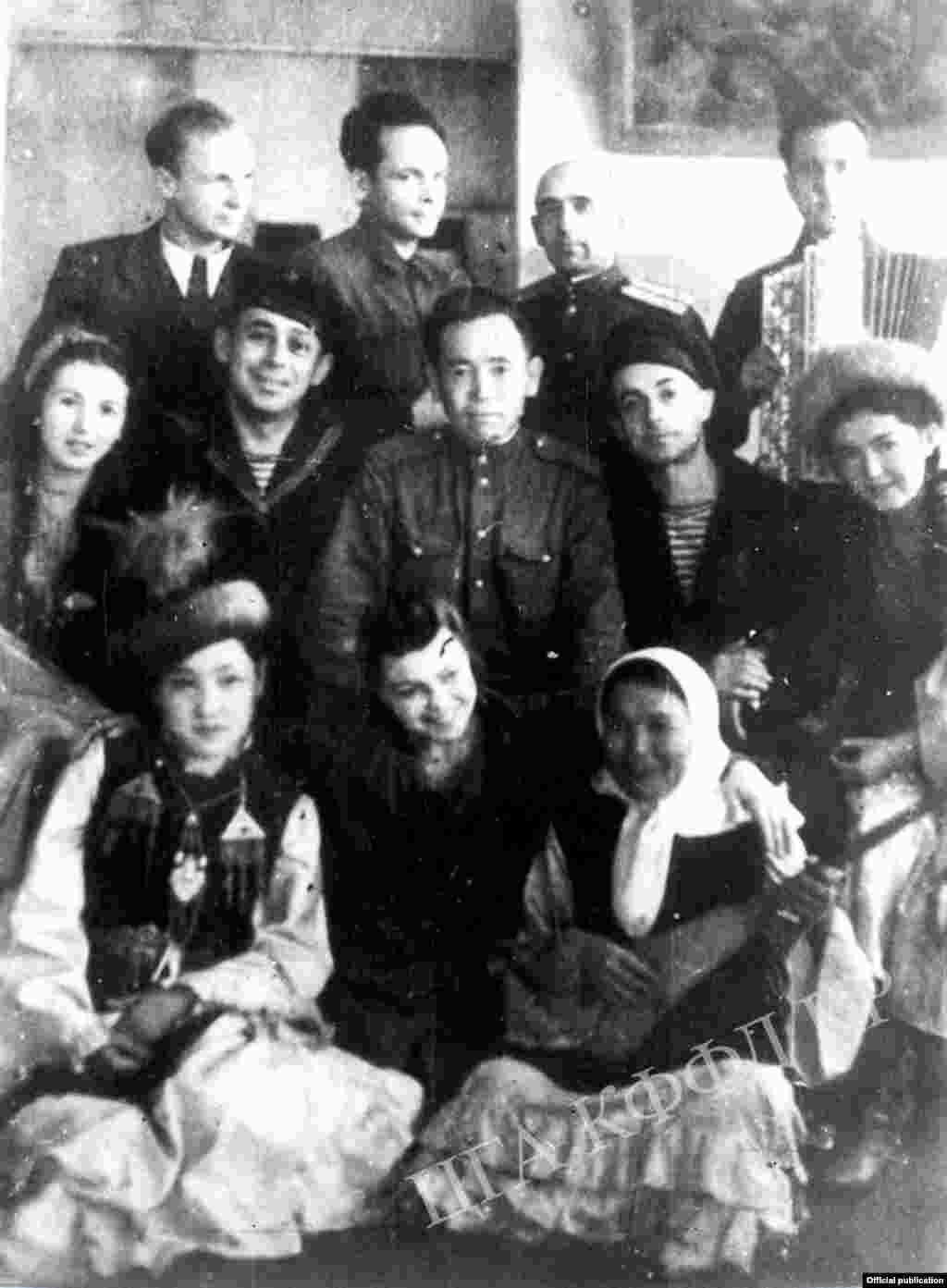 Кыргыз мамлекеттик филармониясынын артисти, акын, фронтовик Көлбай Күмүшалиев менен Мамлекеттик орус драмтеатрынын артисттеринин фронттук бригадасынын жолугушу. 1944-ж. (Сүрөт Кыргызстандын Борбордук мамлекеттик архивинин кинофотофонодокументтер бөлүмүнөн алынды).