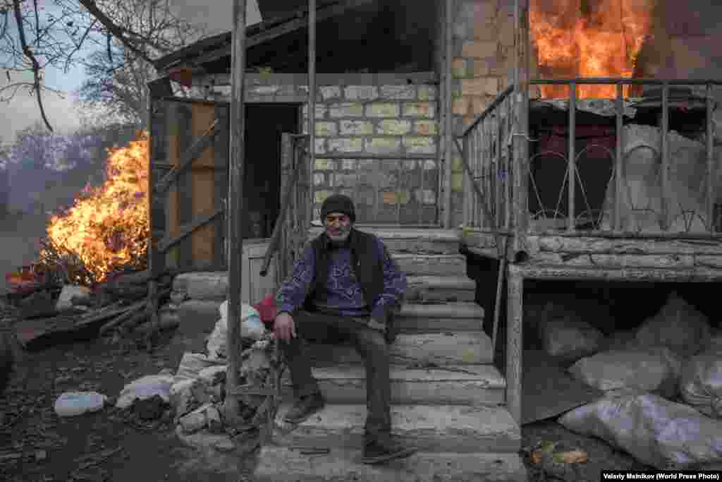 Арэг на ганку палаючага дома ў Нагорным Карабаху (25 лістапада 2020). Некаторыя жыхары спальвалі свае дамы да таго, як гэтыя тэрыторыі пераходзілі пад кантроль Азэрбайджану пасьля падпісаньня мірнага пагадненьня ў лістападзе. Першае месца ў катэгорыі «Навіны», аўтар – Валерый Мельнікаў