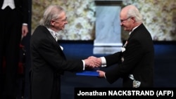 Austrian author Peter Handke (left) receives his Nobel Prize from King Carl XVI Gustaf of Sweden in Stockholm on December 10.