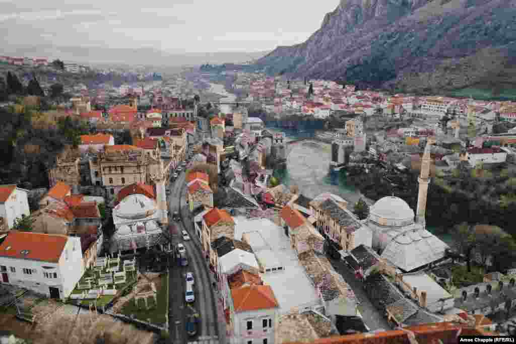 Ovo je Mostar, grad u južnoj Bosni i Hercegovini poznat po kamenom mostu (desno u sredini) preko rijeke Neretve. 