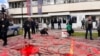Демонстрантите истурија црвена боја пред зградата на полицијата во Нови Пазар, Србија, 12 април 2025 година