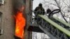A Ukrainian firefighter tackles a blaze in a residential building following a Russian drone attack on Kyiv on January 1. 