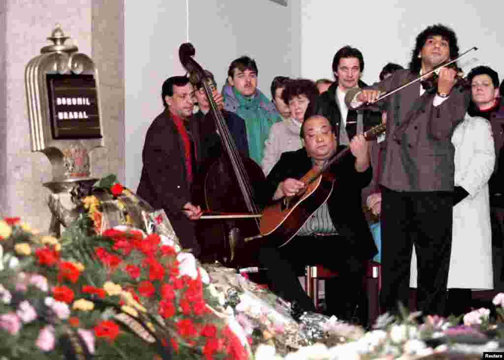 Цыганский ансамбль играет на похоронах Грабала. Он погиб 2 февраля 1997 года, выпав из окна одной из пражских больниц. Как считается, это был несчастный случай - Грабал хотел покормить голубей. 