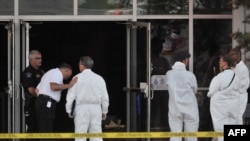Investigators at a movie theater in Colorado where a gunmen went on the rampage, killing 12 people.